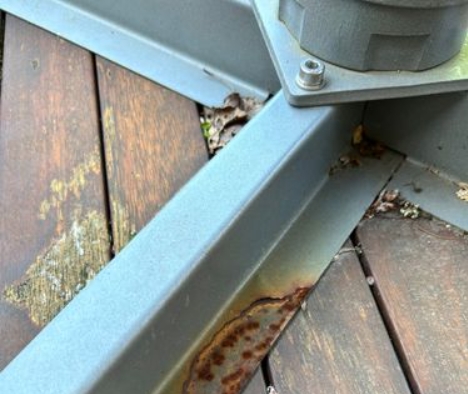 Removing rust from a parasol frame with sandpaper