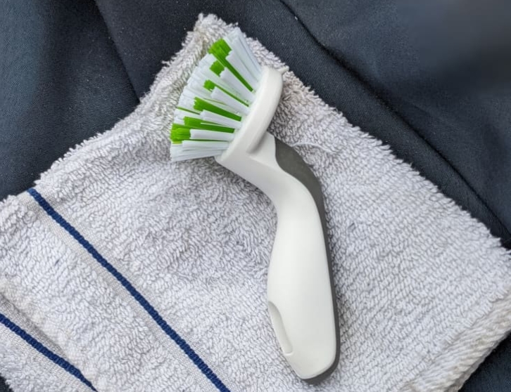 cleaning a parasol canopy with a soft brush and soapy water
