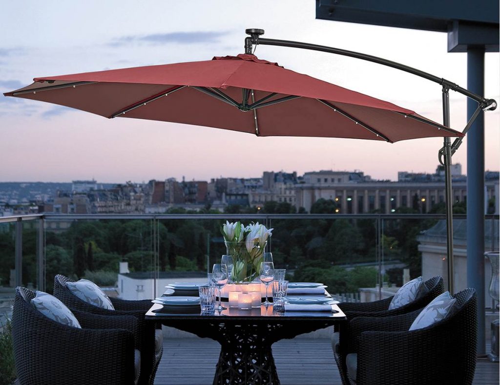 LED umbrella lighting up a backyard patio at dusk